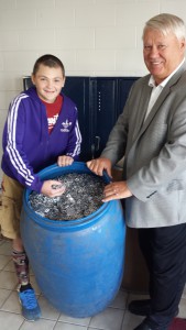 Seth Bayles and principal Gale Ryczek with barrel full of pop tabs