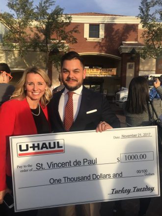 U-Haul donates $1,000 to St. Vincent de Paul during its Turkey Tuesday fundraising efforts at Basha's in Gilbert, Ariz. Pictured are Gilbert Mayor Jenn Daniels, left, and U-Haul Director of External Communications Sebastien Reyes.