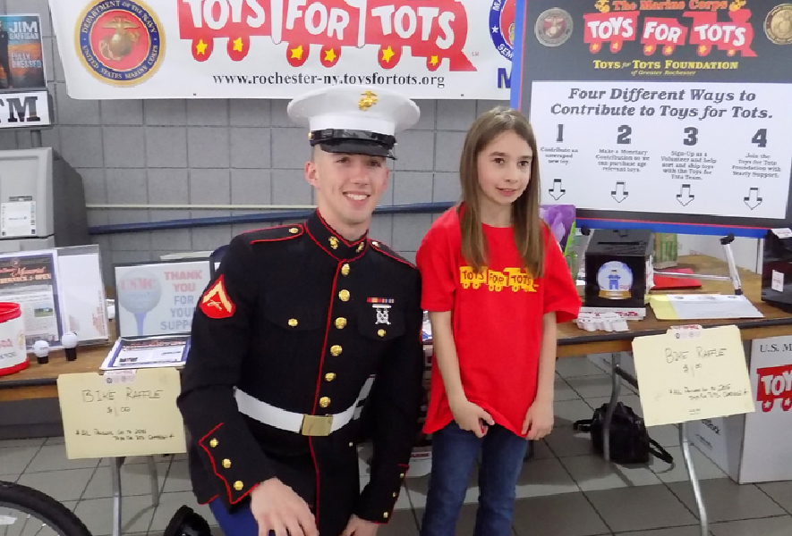 Marine with little girl in front of donation desk