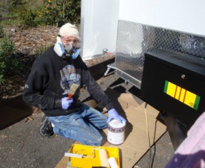 Randy Parent painting his trailer while undergoing chemotherapy for colon cancer.