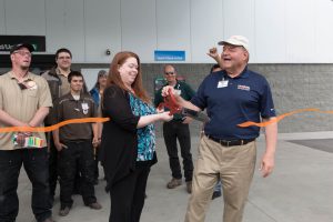 John Norris and Tara Risinger, along with help from U-Haul Company of Alaska Team members, cut the orange ribbon.